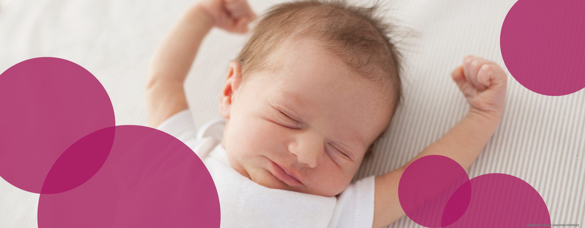 schlafendes Neugeborenes mit nach oben ausgestreckten Armen