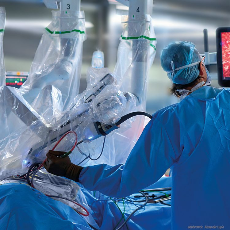 Person in blauer OP-Kleidung in einem Da-Vinci-Operationssaal. Eine Person hält ein Endoskop in den Operationssitus. Beide Personen betrachten das vom Endoskop auf den Monitor projezierte Bild vom OP-Bereich.