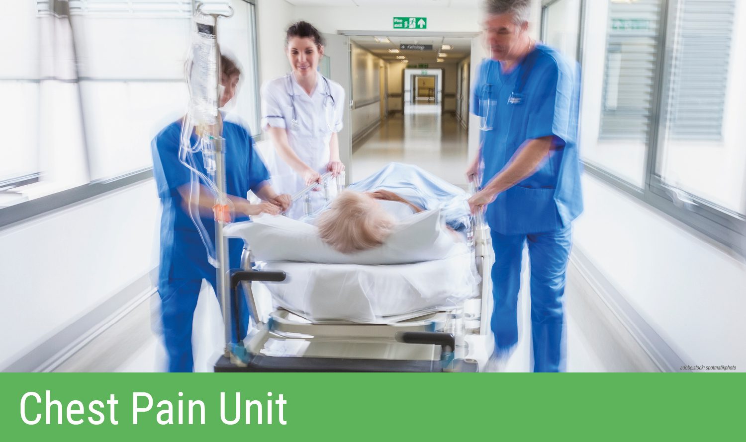 Drei Personen in Krankenhausarbeitskleidung schieben eine Trage mit einer liegenden Person einen Krankenhausflur entlang. Grüner Balken am unteren Bildrand mit Aufschrift Chest Pain Unit.